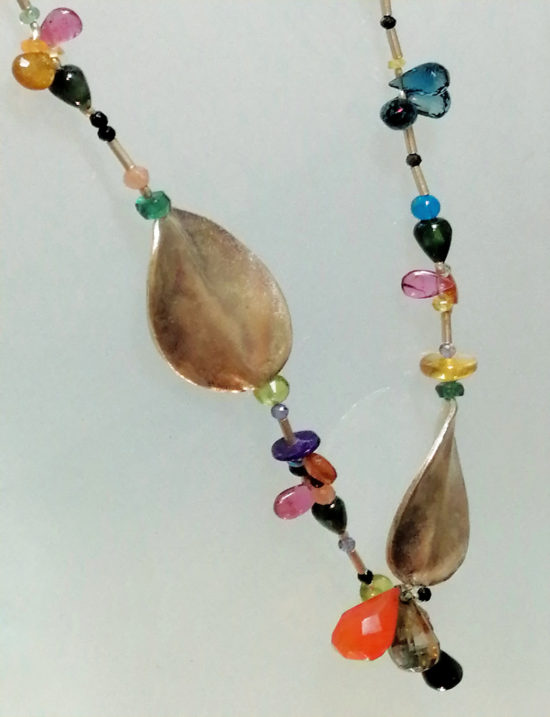 Collar Bunty esta diseñado con dos grandes hojas de Plata colocadas asimétricamente y varios Zafiros verdes, Olivino y otras gemas